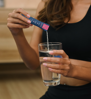 Pouring a Creatine+ stick into a glass of water