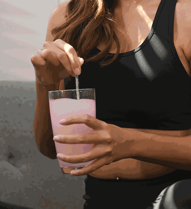 Stirring a pink Creatine+ drink